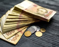 Гривневые купюры и пенсионное удостоверение на столе