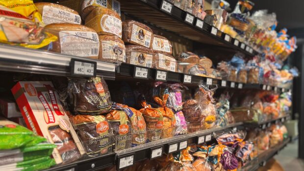 Полиці супермаркету з продуктами та цінниками