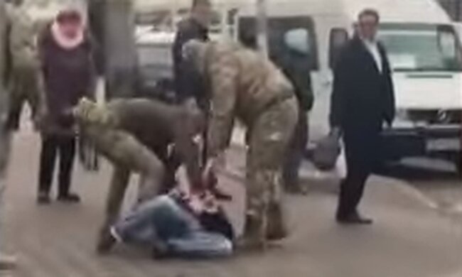 Співробітники ТЦК затримують чоловіка. Фото: скріншот YouTube-відео