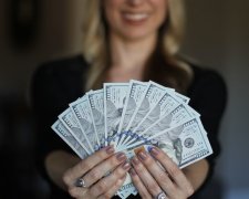 Долар в руках дівчини. Фото: скрін