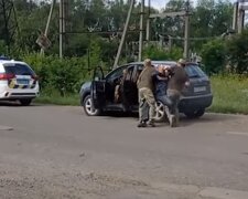 Співробітники ТЦК затримують чоловіка. Фото: скріншот YouTube-відео