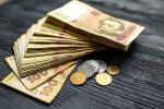 Гривневые купюры и пенсионное удостоверение на столе