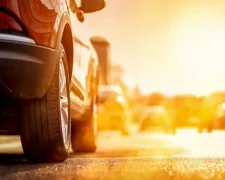Водій вмикає кондиціонер в автомобілі у спеку