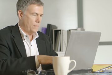 Мужчина с ноутбуком. Фото: скриншот YouTube-видео